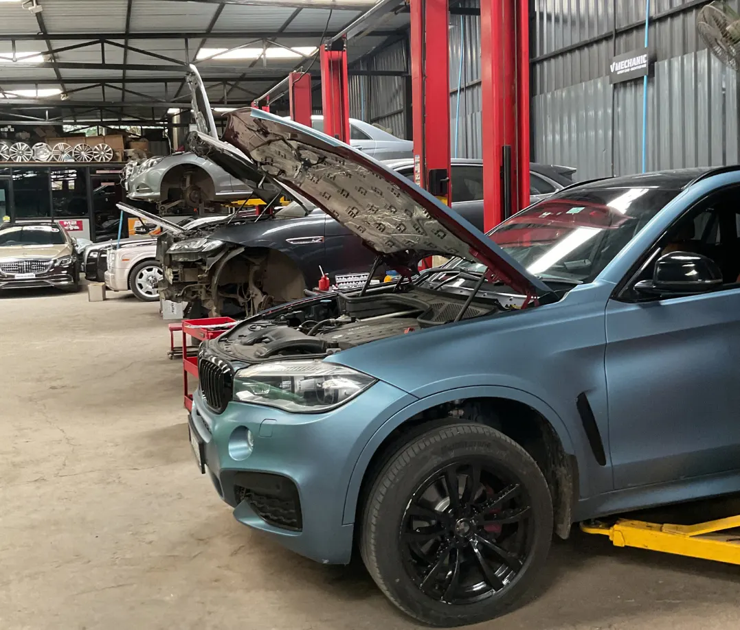 BMW X6 on a lift with bonnet open being serviced at V Mechanic