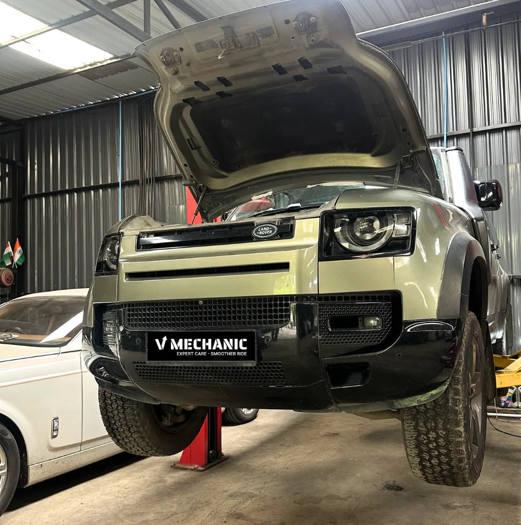 Land Rover Defender raised on a lift for inspection at V Mechanic